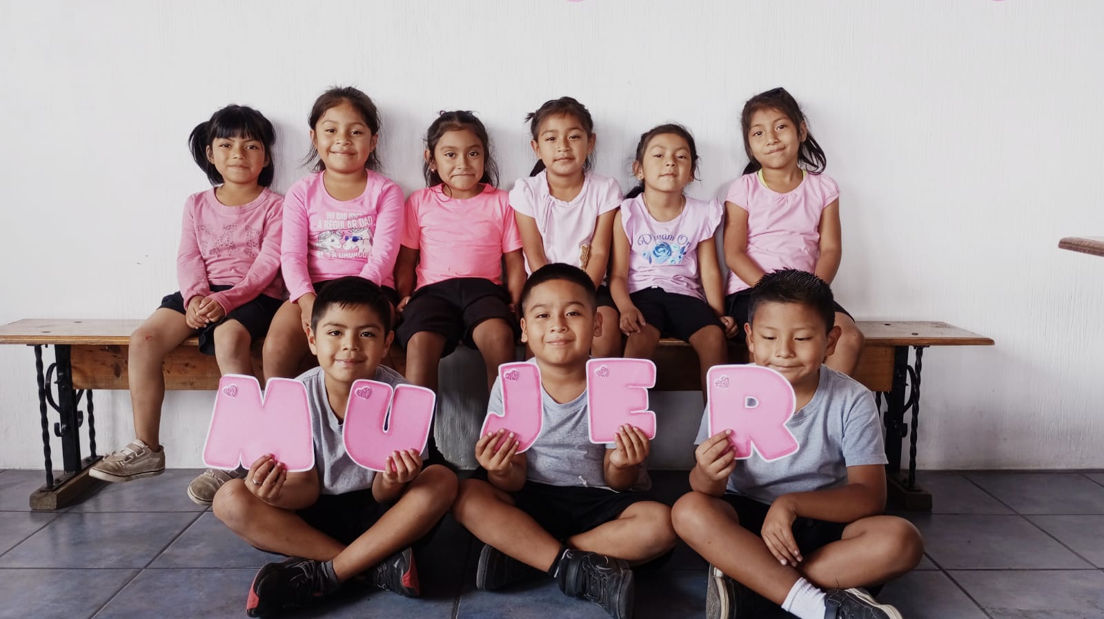 Kinder in rosa Shirts feiern den Muttertag